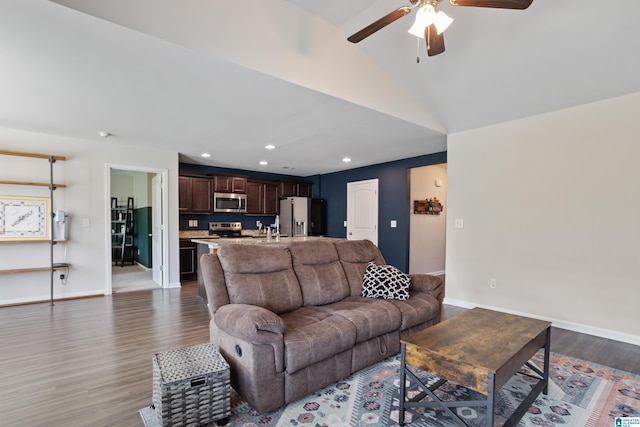 living room featuring ceiling fan, dark hardwood / wood-style floors, vaulted ceiling, and sink