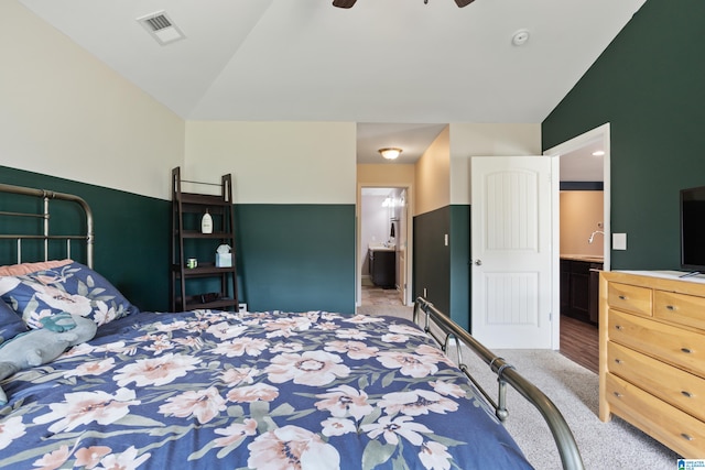 carpeted bedroom featuring ceiling fan, connected bathroom, and lofted ceiling