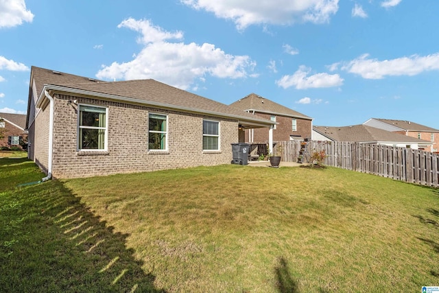 rear view of property with a lawn and a patio area