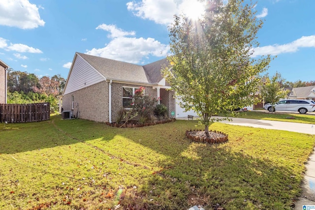 view of front of house with a front lawn and central AC