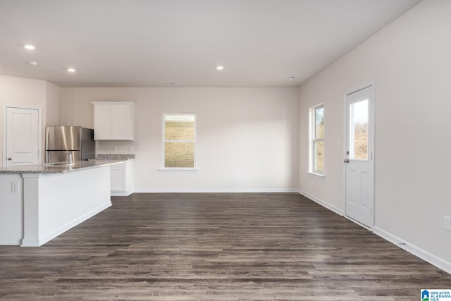 interior space with dark wood-type flooring and a healthy amount of sunlight