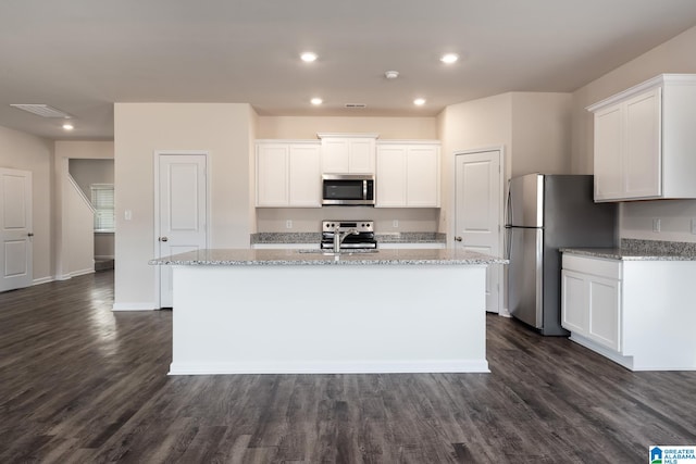 kitchen with white cabinetry, sink, a kitchen island with sink, stainless steel appliances, and light stone countertops