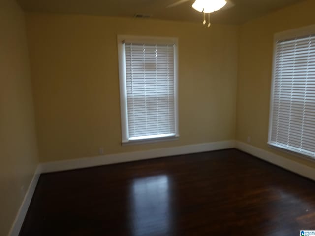 spare room with dark wood-type flooring and ceiling fan