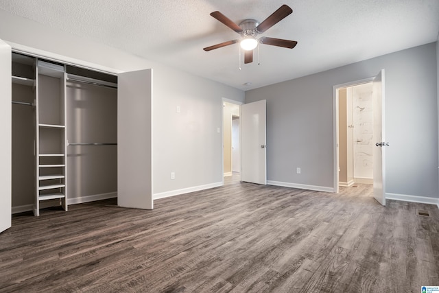 unfurnished bedroom with a closet, ceiling fan, dark hardwood / wood-style flooring, and a textured ceiling