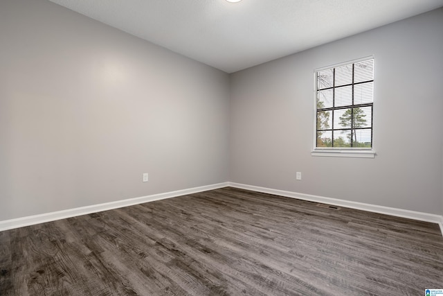 empty room with dark hardwood / wood-style flooring