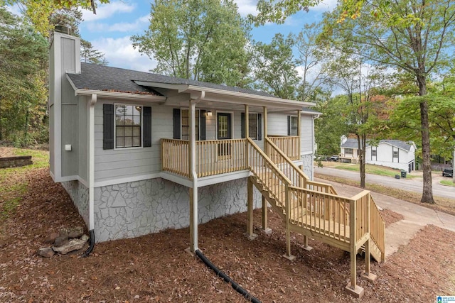 back of property featuring covered porch