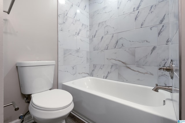 bathroom featuring toilet and tiled shower / bath