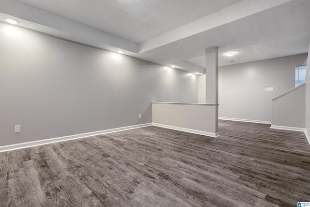 basement featuring dark hardwood / wood-style floors and a textured ceiling