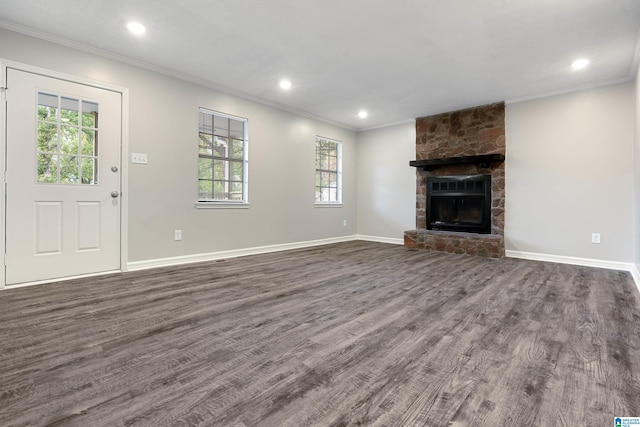 unfurnished living room featuring a fireplace, crown molding, and dark wood-type flooring