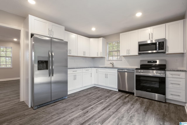 kitchen featuring white cabinetry, appliances with stainless steel finishes, dark hardwood / wood-style floors, and plenty of natural light