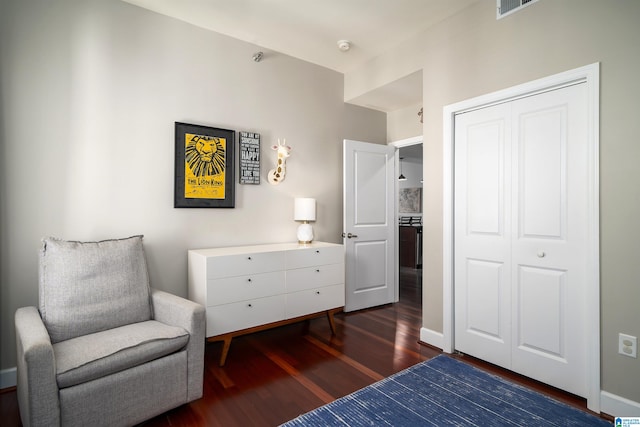 bedroom with dark wood-type flooring and a closet