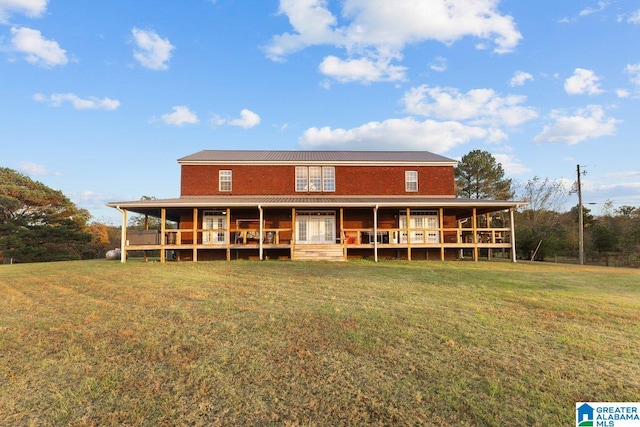 back of property featuring covered porch and a lawn