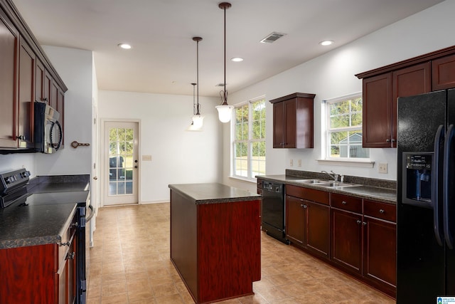 kitchen featuring hanging light fixtures, black appliances, sink, and a center island