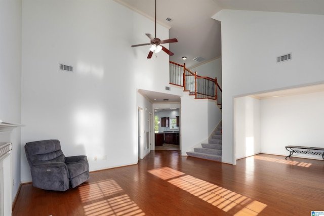 interior space featuring ceiling fan, dark hardwood / wood-style floors, crown molding, and high vaulted ceiling