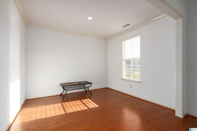 unfurnished room featuring hardwood / wood-style flooring and crown molding