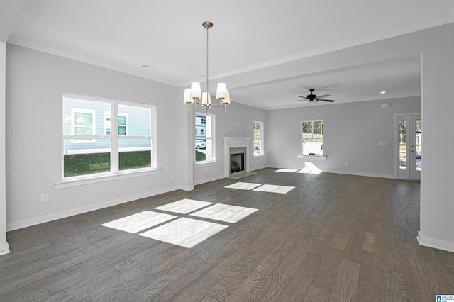 unfurnished living room with a wealth of natural light, dark hardwood / wood-style floors, ceiling fan with notable chandelier, and crown molding