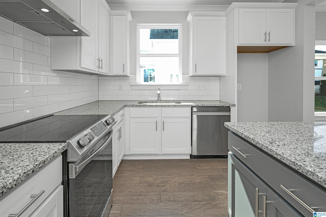 kitchen featuring white cabinets, wall chimney exhaust hood, and stainless steel appliances