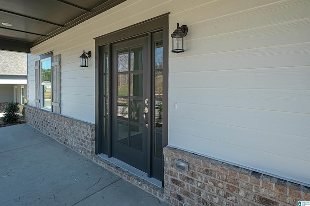 view of exterior entry featuring covered porch