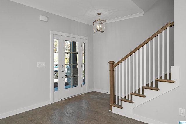 entryway featuring dark wood-type flooring, an inviting chandelier, and crown molding