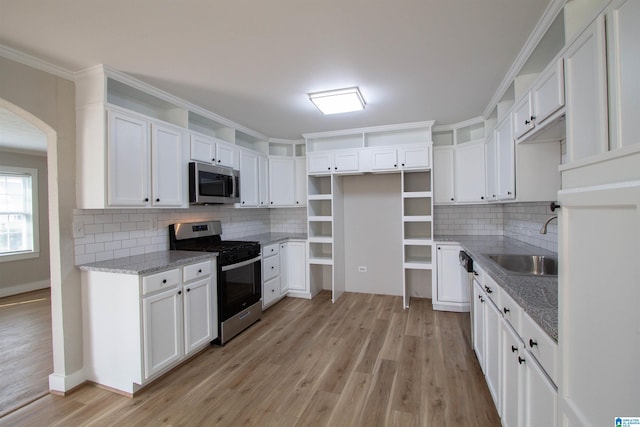 kitchen with backsplash, appliances with stainless steel finishes, sink, and white cabinets