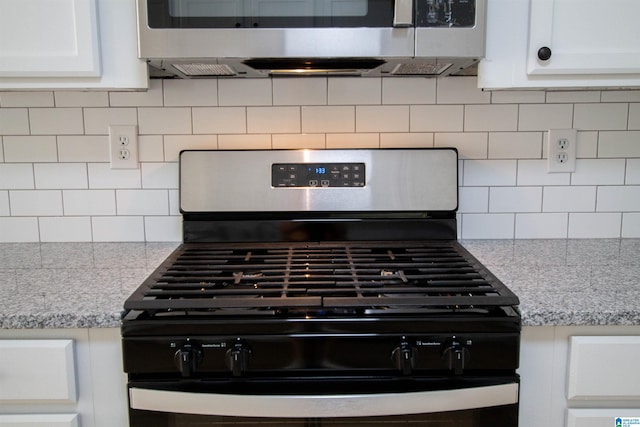 details featuring light stone countertops, decorative backsplash, and appliances with stainless steel finishes