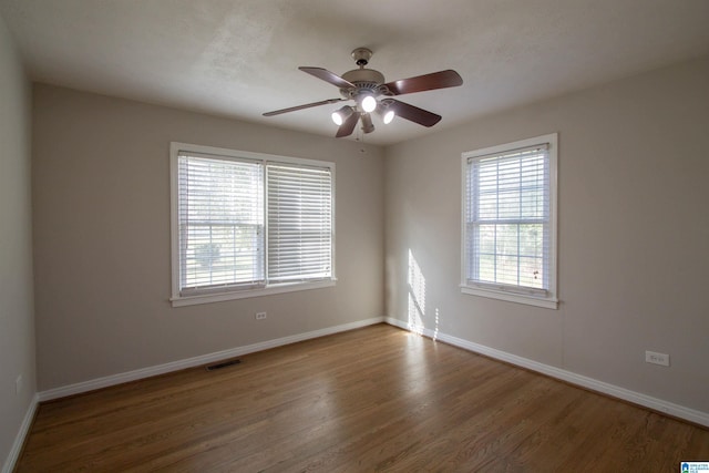 empty room with ceiling fan and dark hardwood / wood-style flooring