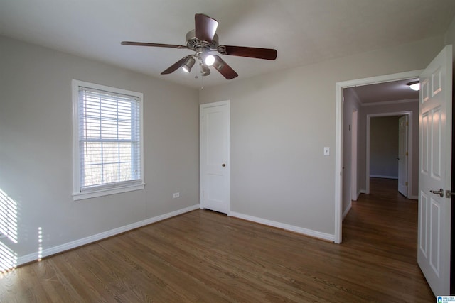 unfurnished bedroom with ceiling fan, dark hardwood / wood-style floors, and crown molding