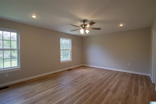 unfurnished room featuring ceiling fan, light hardwood / wood-style floors, and a healthy amount of sunlight