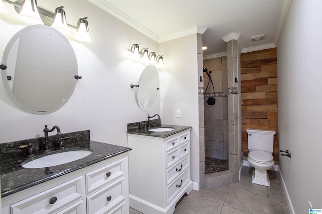 bathroom with tiled shower, ornamental molding, vanity, tile patterned flooring, and toilet