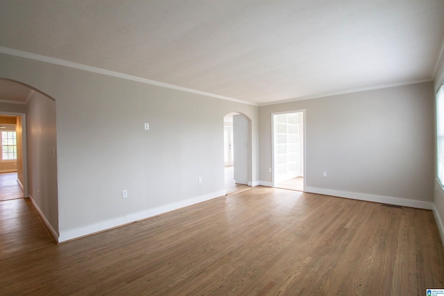 empty room featuring hardwood / wood-style flooring and crown molding