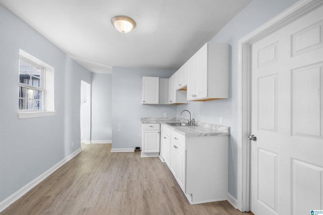 kitchen with sink, white cabinets, and light hardwood / wood-style floors