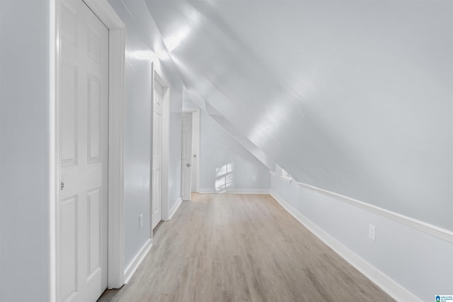 additional living space featuring light hardwood / wood-style flooring and lofted ceiling