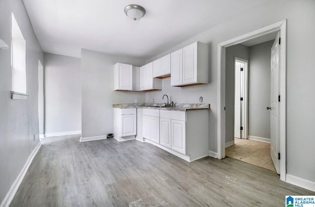 kitchen featuring sink, white cabinets, and light hardwood / wood-style floors