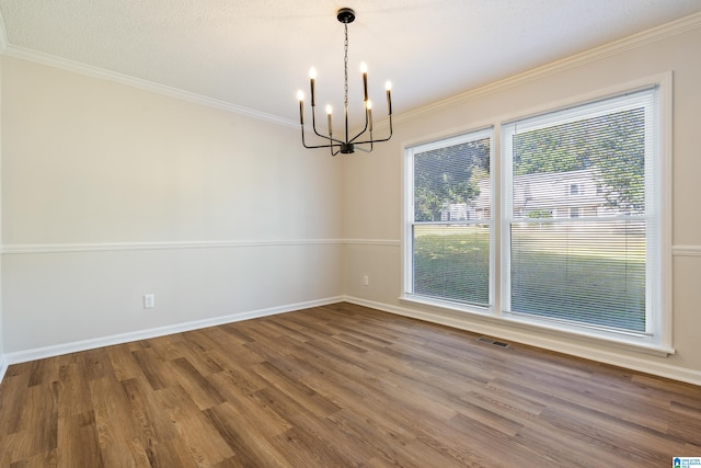 unfurnished dining area with a textured ceiling, hardwood / wood-style flooring, crown molding, and an inviting chandelier