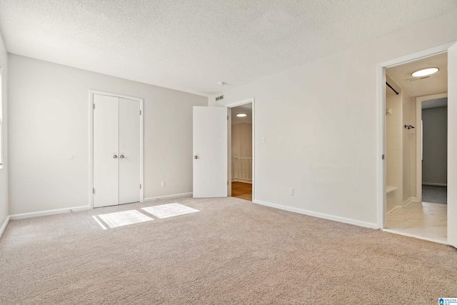 carpeted empty room featuring a textured ceiling