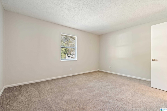 carpeted spare room featuring a textured ceiling