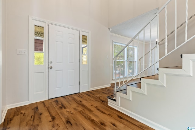 foyer entrance featuring hardwood / wood-style floors and crown molding