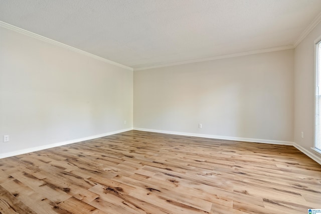 empty room with light wood-type flooring, a textured ceiling, and crown molding