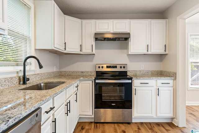 kitchen with stainless steel appliances, white cabinetry, and sink