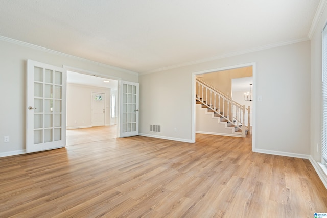 empty room featuring french doors, ornamental molding, and light hardwood / wood-style flooring