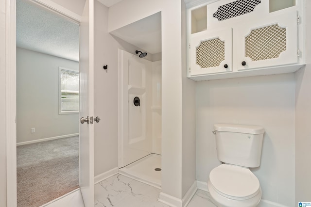 bathroom with toilet, a shower, and a textured ceiling