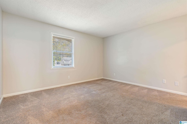 carpeted empty room featuring a textured ceiling