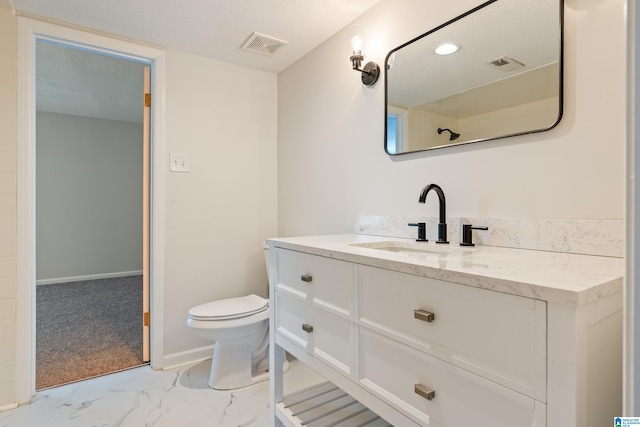 bathroom featuring vanity, toilet, and a textured ceiling