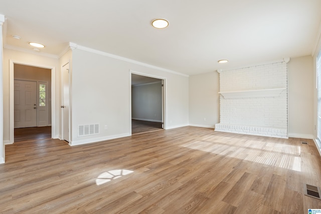 unfurnished living room featuring light wood-type flooring, a fireplace, and crown molding