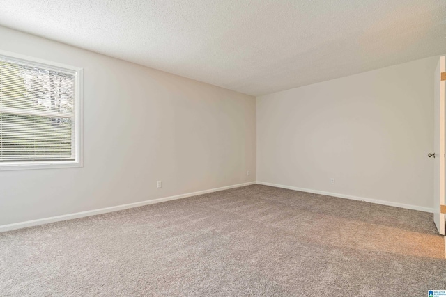 carpeted empty room featuring a textured ceiling