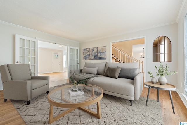 living room featuring ornamental molding, french doors, and light hardwood / wood-style floors