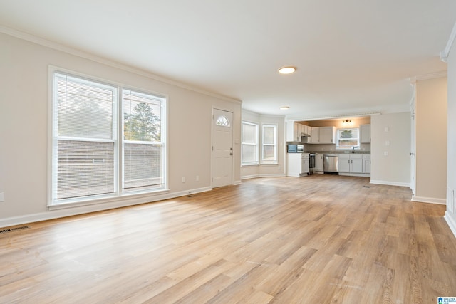 unfurnished living room featuring light wood-type flooring, sink, and ornamental molding