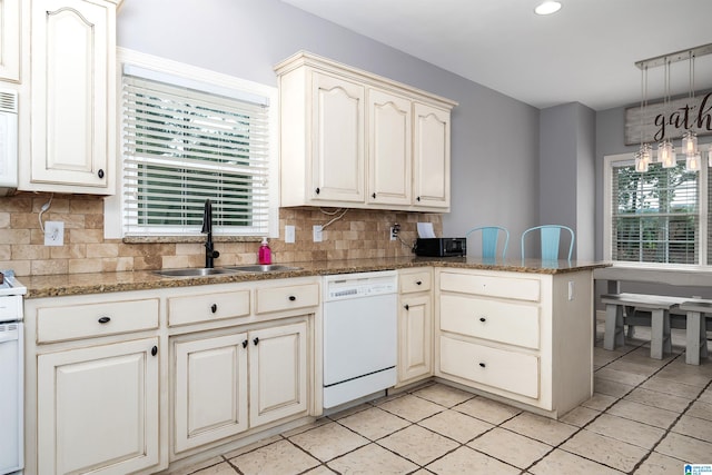 kitchen featuring kitchen peninsula, white appliances, sink, and backsplash