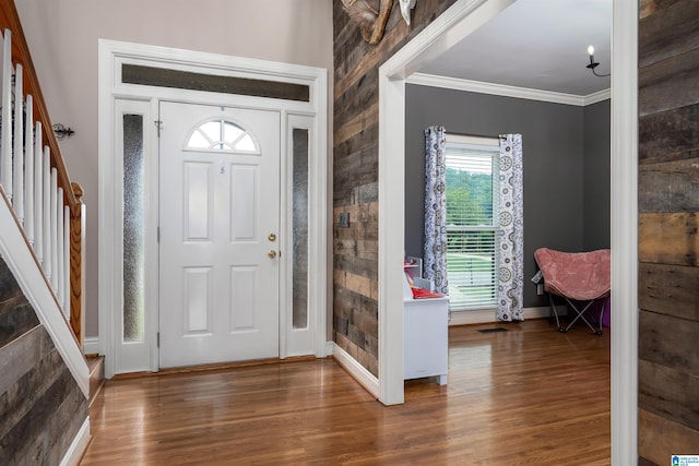 foyer with dark wood-type flooring and ornamental molding