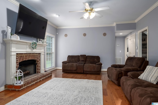 living room with a fireplace, hardwood / wood-style flooring, crown molding, and ceiling fan